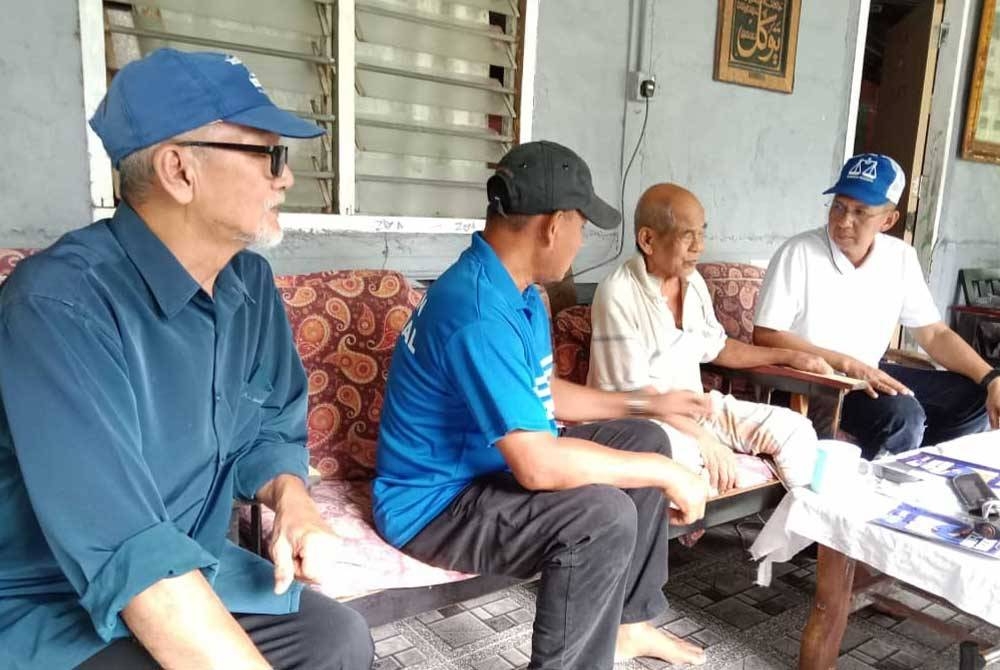 Saiful Yazan (kanan) ketika menyantuni penduduk sekitar Kampung Malan,Johol.