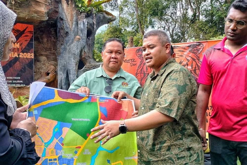 Rais (tiga,kiri) ketika menunjukkan pelan pembinaan Taman Safari di Ayer Keroh, Melaka.