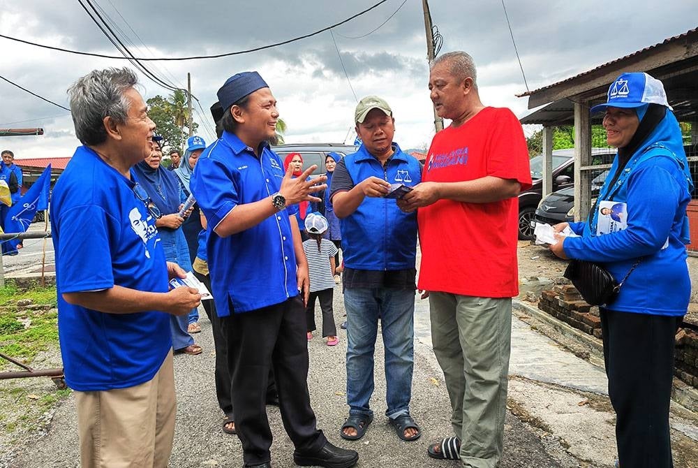 Mohd Asna (dua dari kiri) beramah mesra dengan penduduk Kampung Daching, Lenggeng.