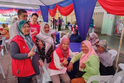 Noorzunita Begum (dua kanan) berkesempatan merakam gambar dengan penduduk ketika menyantuni mereka pada Sabtu.