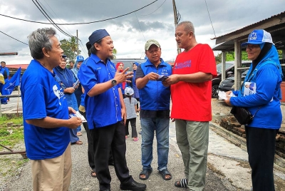 Mohd Asna (dua dari kiri) beramah mesra dengan penduduk Kampung Daching, Lenggeng.