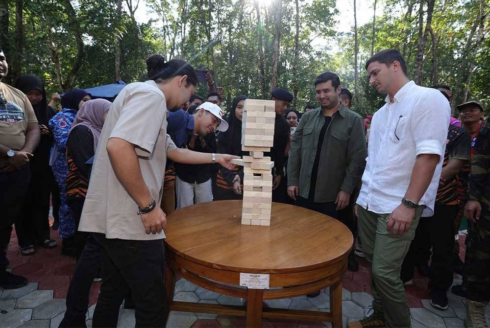 Tunku Idris Iskandar, Tunku Abdul Rahman, Tunku Abu Bakar dan Dennis Muhammad menyertai rakyat bermain permainan blok jengga gergasi. - Foto Kelab Media Johor