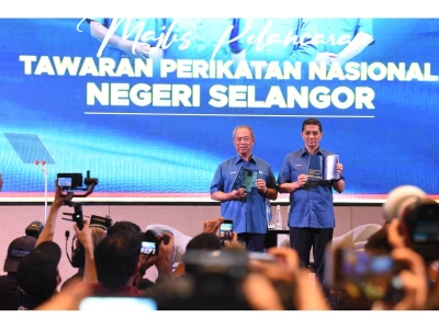 Muhyiddin (kiri) dan Azmin menunjukkan buku Tawaran Pakej Rangsangan Ekonomi Prihatin Selangor yang bertemakan “Selangor Baharu, Kita Bangkit” pada Jumaat.