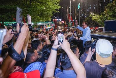 Anwar melambaikan tangan kepada penyokong ketika hadir pada Ceramah Jelajah Perpaduan Madani di Petaling Jaya malam Ahad. - Foto Bernama