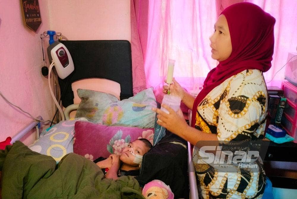 Shahmiza memberi susu kepada Qaseh di rumahnya di Kampung Kurnia.