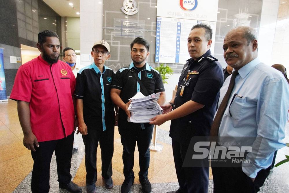 Hishamuddin (tengah) menyerahkan penyata tambahan dan surat mohon status laporan polis kepada seorang pegawai JSJK di Kuala Lumpur pada Isnin.