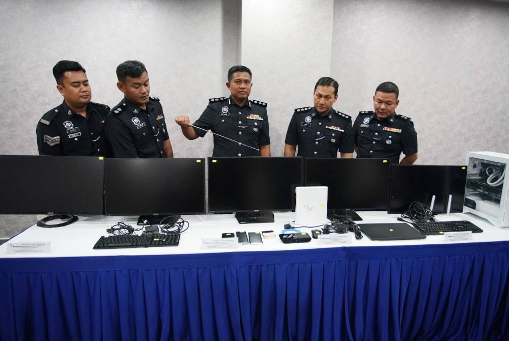 Noor Dellhan (tengah) menunjukkan peralatan perjudian berkapasiti tinggi yang dirampas dalam serbuan di sebuah kondominium mewah di Kia Peng, Kuala Lumpur pada Sabtu.