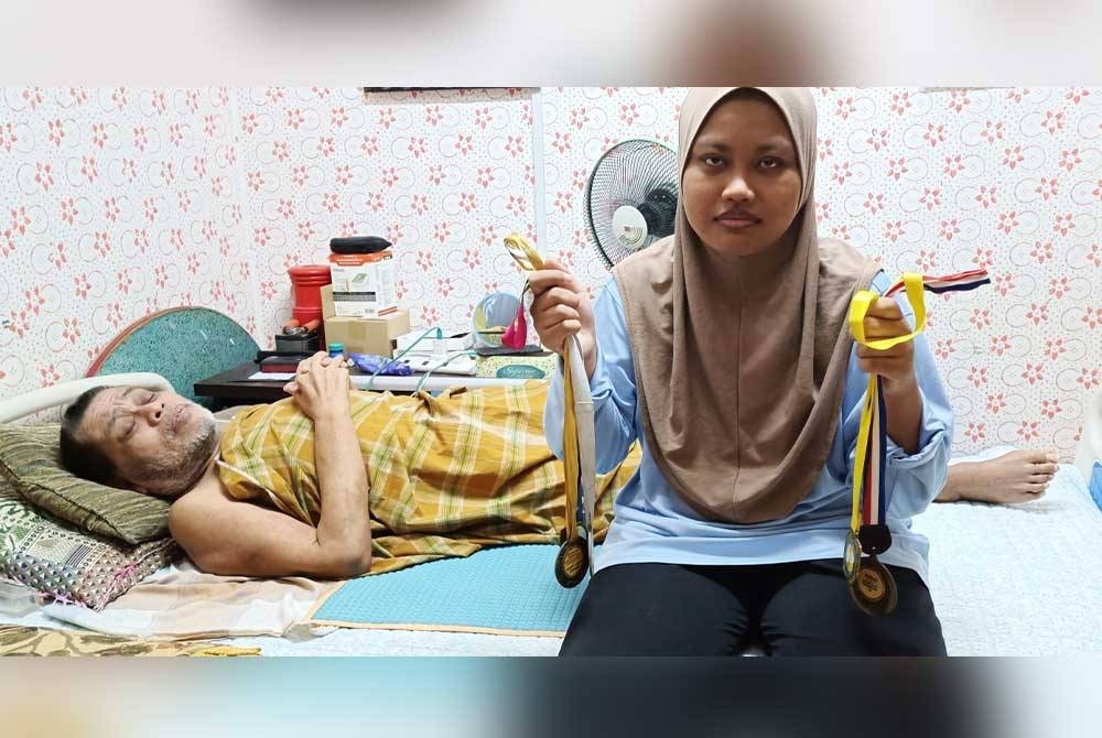Nurnajwa menunjukkan antara medal yang dimenanginya ketika bergiat aktif dalam aktiviti sukan di peringkat sekolah. Turut kelihatan bapanya, Rosli.