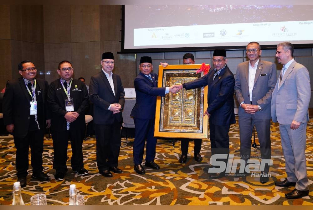 Harun KC Ahmmu (tiga dari kanan) menyampaikan cenderahati kepada Mohd Na'im pada Majlis Perasmian Pameran Pelancongan Antarabangsa Umrah dan Haji ke-12 di Hotel Four Seasons Kuala Lumpur pada Isnin. - Foto Sinar Harian MOHD HALIM ABDUL WAHID