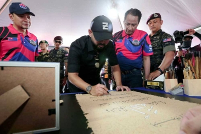 Tunku Ismail (tengah) mempamerkan kemahiran dalam seni khat. - Foto Kelab Media Johor