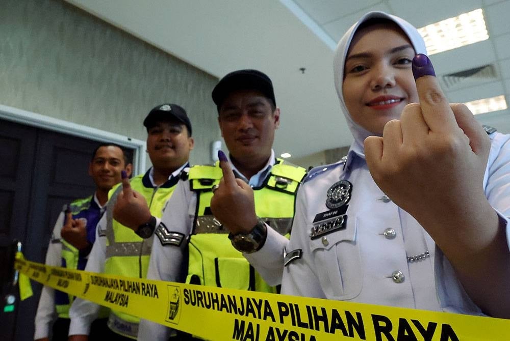 Anggota Polis Trafik menunjukkan jari mereka setelah menunaikan tanggungjawab pada proses pengundian awal sempena Pilihan Raya Negeri (PRN) di Ibu Pejabat Kontinjen Polis Kedah (IPK) hari ini.