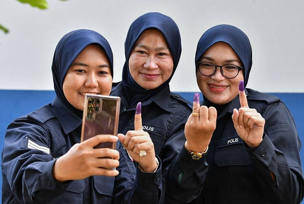 Gelagat Anggota Polis Diraja Malaysia (PDRM) berswafoto dengan jari yang mempunyai kesan calitan dakwat kekal selepas proses pengundian awal sempena Pilihan Raya Negeri (PRN) di Kem Batalion 8 Pasukan Gerakan Am (PGA), Pengkalan Chepa hari ini.