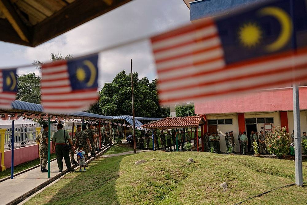 Anggota tentera beratur untuk menunaikan tanggungjawab mengundi awal di Pusat Pengundian Awal Sekolah Kebangsaan Kem Lapangan Terbang Sungai Layar bagi kerusi DUN N26 Tanjong Dawai, sempena Pilihan Raya Negeri Kedah, hari ini.