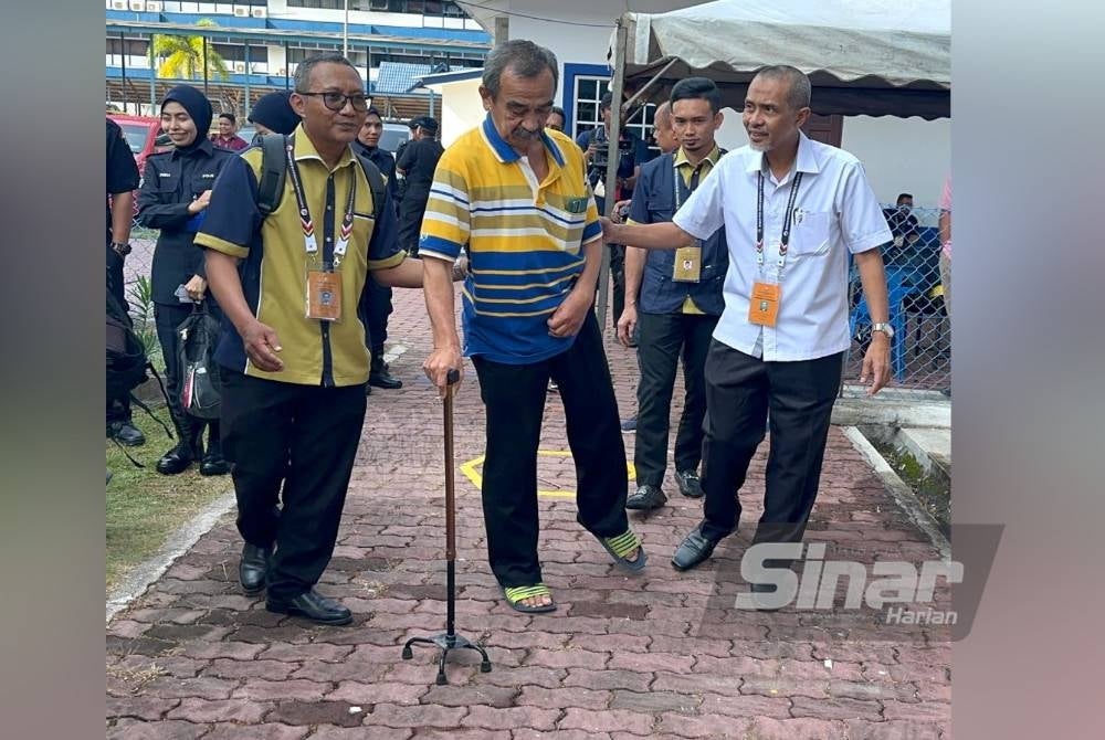 Che Mustapa (tengah) tidak ketinggalan melaksanakan tanggungjawab mengundi awal bagi PRN biarpun datang dengan bertongkat di pusat pengundian Taska, IPK Kelantan di Kota Bharu pada Selasa.