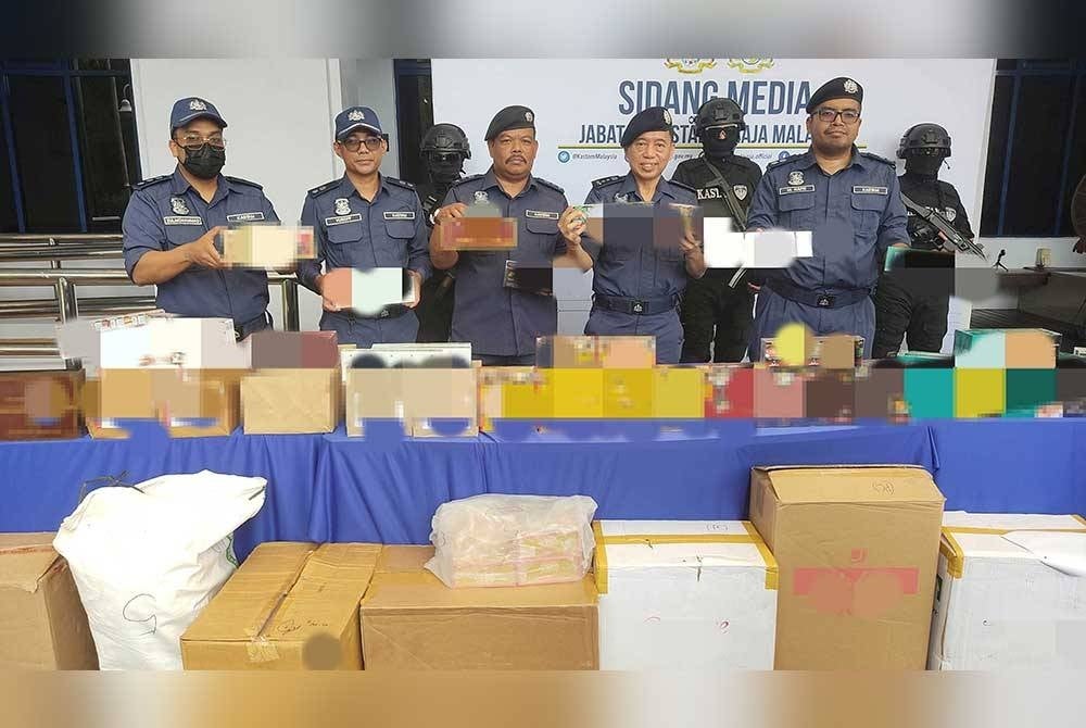 Pun Sian (dua dari kanan) menunjukkan rampasan rokok hasil serbuan di sebuah premis di Kepong, Kuala Lumpur, 1 Ogos lalu.