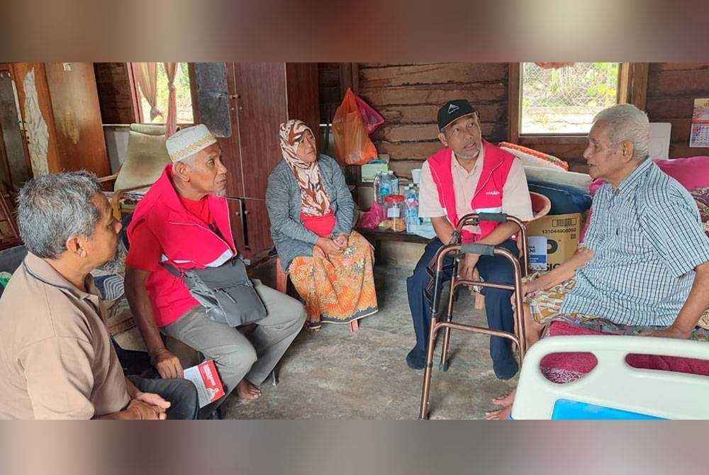 Bakri ( dua dari kanan ) ketika menziarahi penduduk Kampung Kuala Pah yang sakit pada Selasa.
