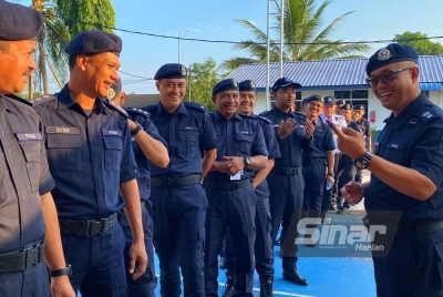 Zaizul Rizal (kanan) menunjukkan jari beliau kepada pegawai dan anggota sebagai tanda orang pertama yang melakukan pengundian seawal jam 8.05 pagi di IPD Pasir Puteh.