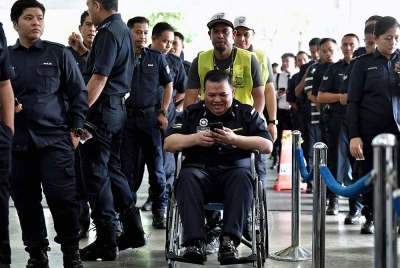 Petugas Suruhanjaya Pilihan Raya (SPR) membantu dan memudahkan pergerakan anggota polis yang berkerusi roda akibat masalah kesihatan bersemangat hadir untuk manunaikan tanggungjwabnya sebagai pengundi awal sempena Pilihan Raya Negeri Selangor di Dewan D'Cerana, Ibu Pejabat Polis Kontinjen Selangor hari ini.