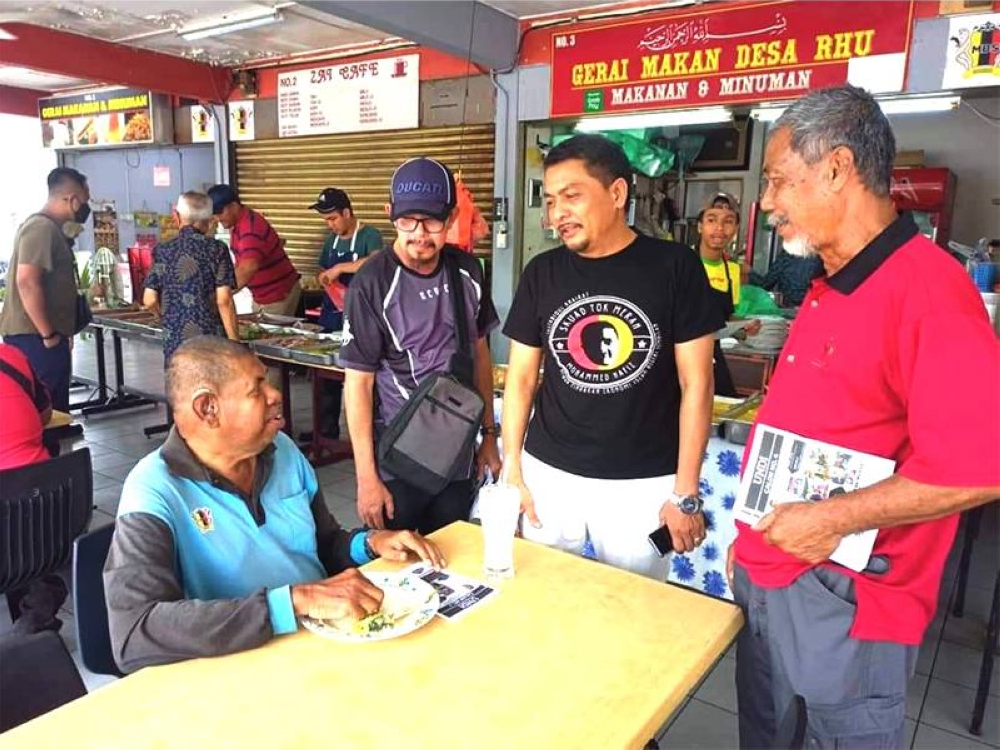 Mohammed Hafiz (dua dari kanan) beramah mesra dengan penduduk Sikamat.
