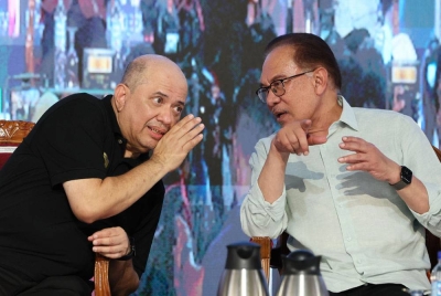 Anwar (kanan) memperkatakan sesuatu kepada Pengerusi Lembaga Pemegang Amanah, Amanah Ikhtiar Malaysia (AIM) Datuk Seri Syed Hussian Syed Junid pada Majlis Perasmian Karnival Sahabat Usahawan MADANI Amanah Ikhtiar Malaysia Wilayah Terengganu pada Rabu.- Foto: Bernama