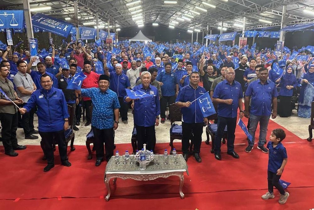 Dr Ahmad Zahid (tengah) bersama kepimpinan BN dan penyokong PN-BH mengibarkan bendera tanda semangat menjelang PRN Sabtu ini.