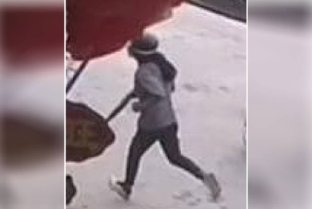 Tangkap layar rakaman CCTV menunjukkan suspek memegang payung selepas samun sebuah butik produk kecantikan di Batu Gajah. Foto: ihsan polis
