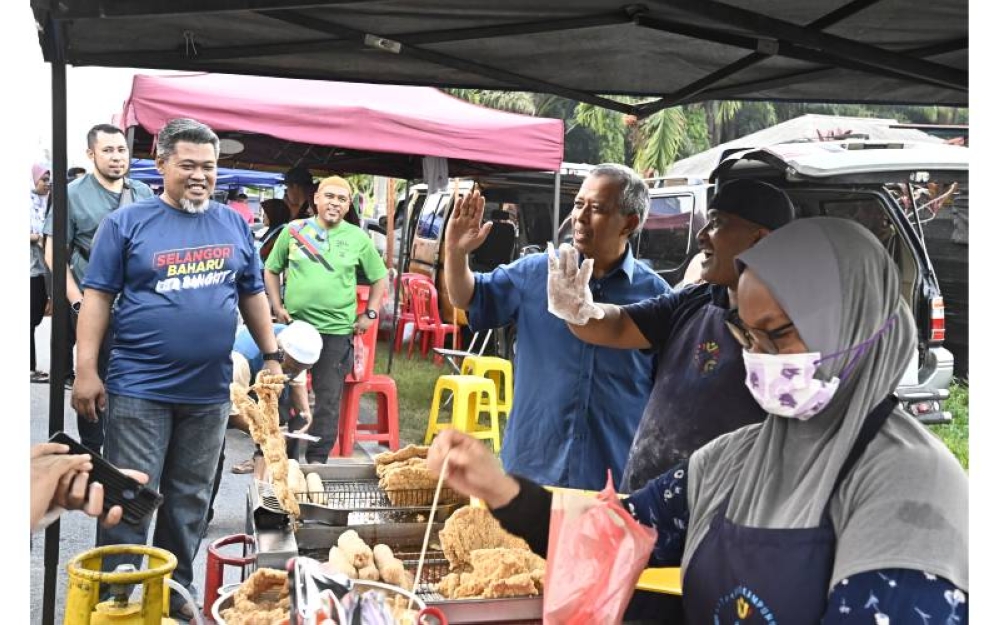 Jamil (tiga dari kanan) beramah mesra bersama seorang peniaga ketika berkempen tapak pasar malam di DUN Dengkil.