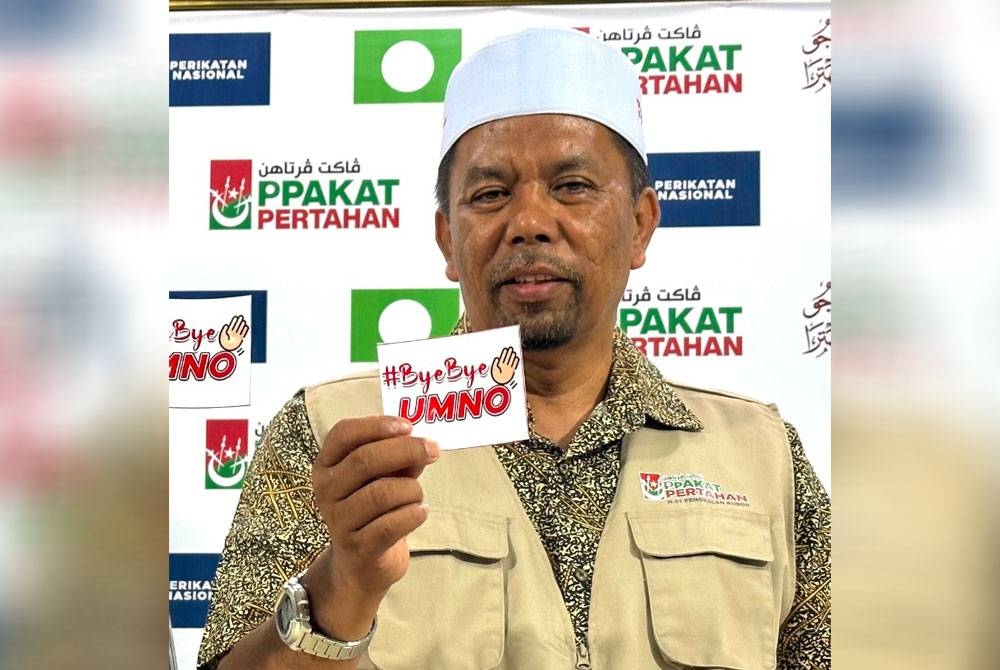 Wan Roslan menunjukkan pelekat #ByeBye UMNO yang dibuat oleh bekas ahli UMNO di Ketereh.