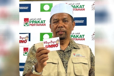 Wan Roslan menunjukkan pelekat #ByeBye UMNO yang dibuat oleh bekas ahli UMNO di Ketereh.