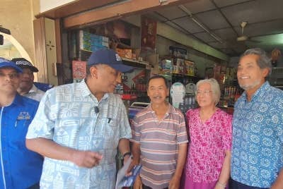 Khairy (kanan) dan Reezal (dua dari kiri) ketika turun berkempen di Pekan Lama Kepala Batas, pada Khamis.