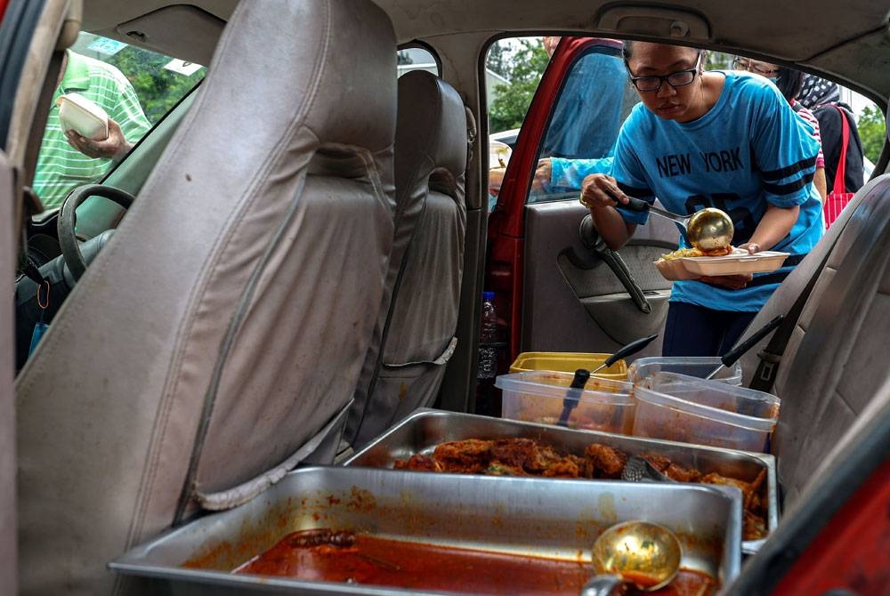 Antara pelanggan mengambil lauk di kereta. - Foto: Bernama