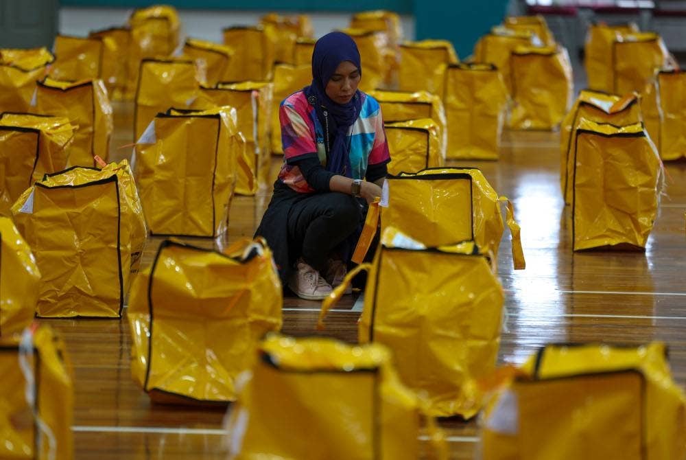 Petugas SPR membuat persiapan akhir dengan memeriksa peralatan mengundi bagi DUN N.13 Sikamat sebelum dibawa ke Pusat Mengundi menjelang PRN di Dewan Komuniti Taman Coral Heights Sikamat hari ini. - Foto Bernama