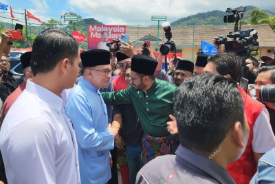 Anwar bersalaman dengan penyokongnya ketika membuat lawatan di sebuah kedai makan di Sungai Pinang, Balik Pulau pada Jumaat.