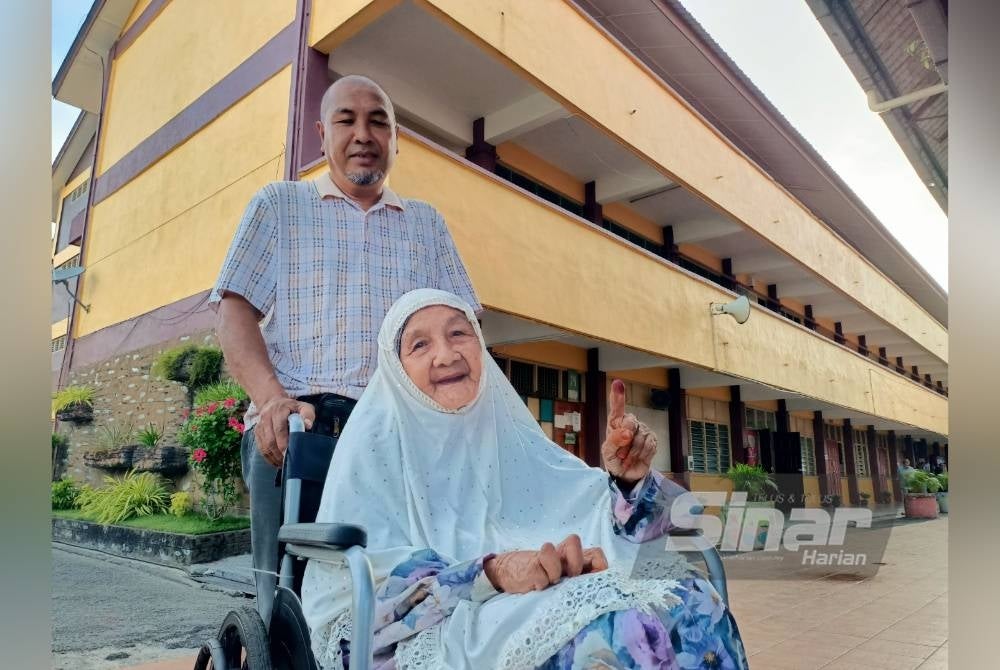 Asa ditemani anaknya, Azmi selesai membuang undi bagi kerusi DUN Penaga di Pusat Mengundi SK Permatang Janggus pada Sabtu.