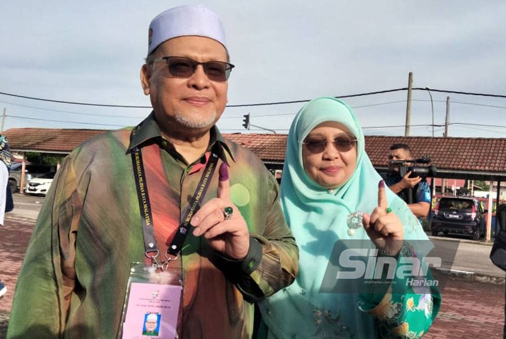 Mohd Amar dan isteri, Datin Hasmani Hussain menunjukkan jari selepas mengundi di SK Panji.