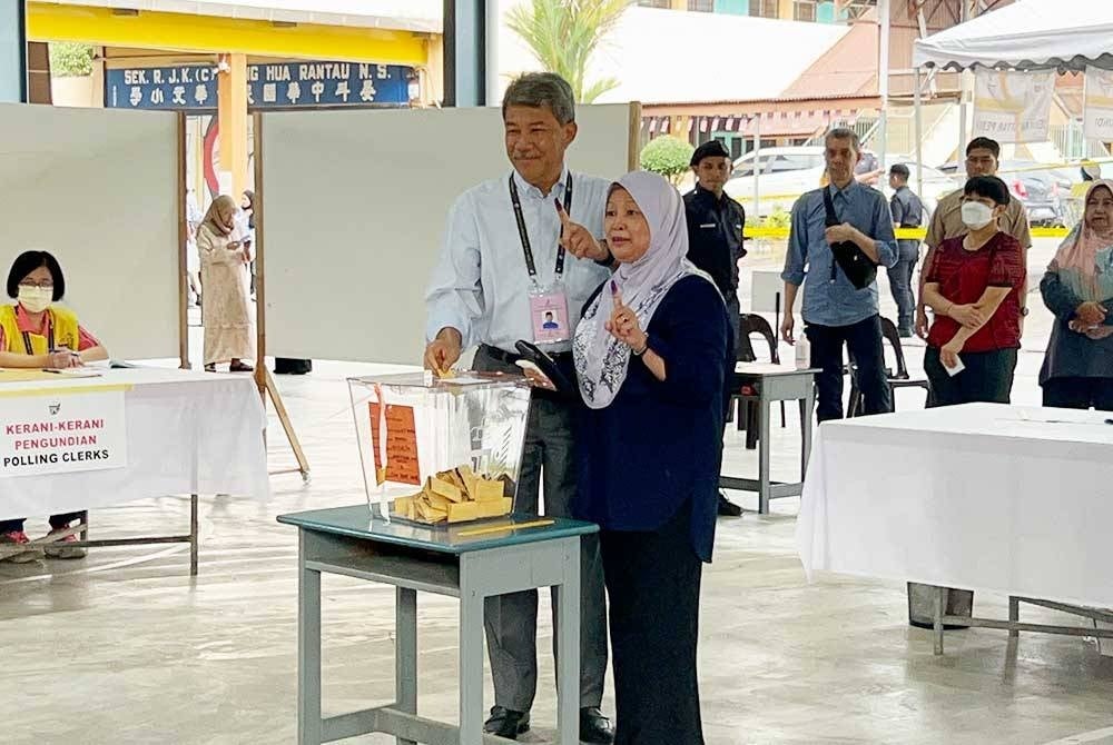 Mohamad dan isteri, Datin Seri Raja Salbiah Tengku Nujumudin selesai mengundi di Sekolah Rendah Jenis Kebangsaan Chung Hua di Rantau pada Sabtu.