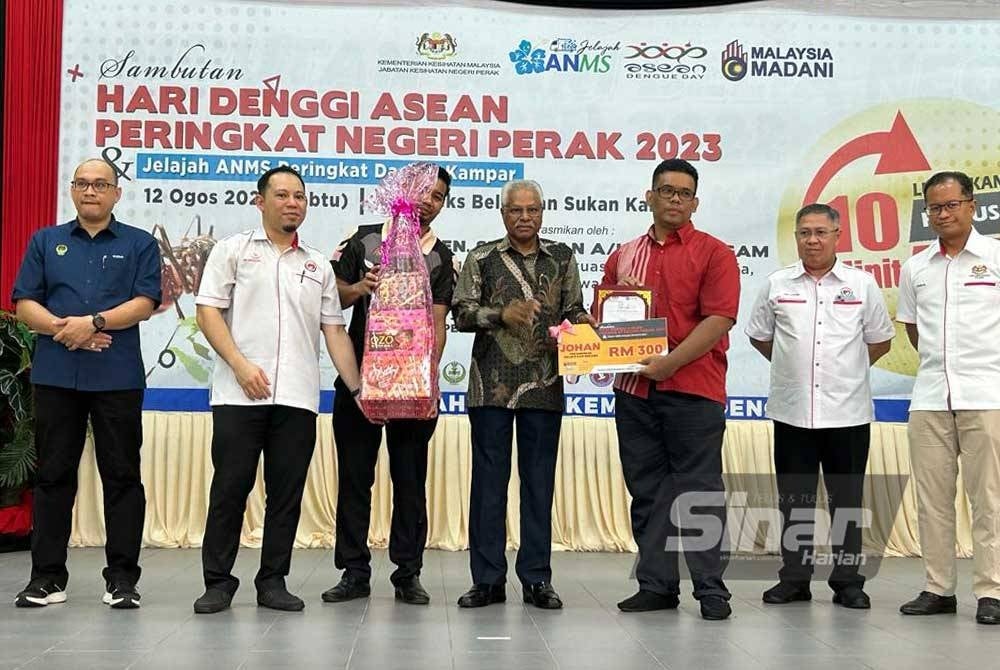 Sivanesan (tengah) menyampaikan hadiah kepada peserta yang menyertai sambutan Hari Denggi Asean Peringkat Negeri Perak di Kompleks Rakan Muda, Kampar pada Sabtu.
