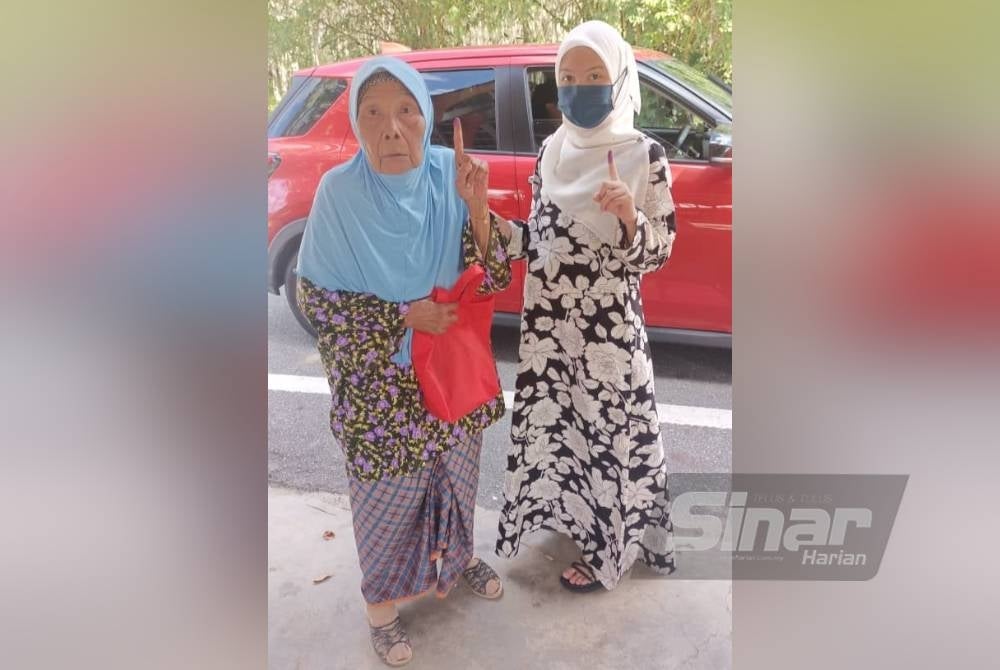 Tumini Kasiman ditemani cucu, lSiti Aishah membuang undi di SK Padang Chichak.