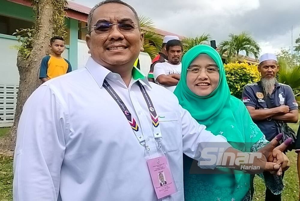 Muhammad Sanusi bersama isteri selesai membuang undi di Pusat Pengundian Sekolah Kebangsaan Bandar Baru Beris Jaya Sik.