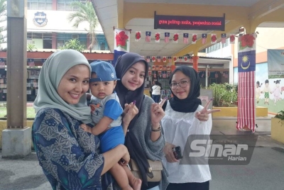 Ernita (kiri) bersama anak, Harith Marteen serta dua anak saudara selesai membuang undi di SJK (C) Selayang Baru jam 2 petang.