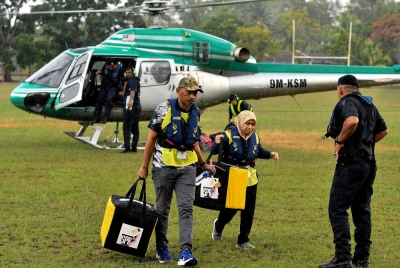 Petugas SPR menggunakan perkhidmatan helikopter bagi membawa peti undi dari Pusat Mengundi Sekolah Kebangsaan Pulau Redang ke pusat pengundian di Institut Pendidikan Guru Kampus Dato Razali Ismail, Batu Rakit untuk tujuan pengiraan sempena PRN hari ini. - Foto Bernama