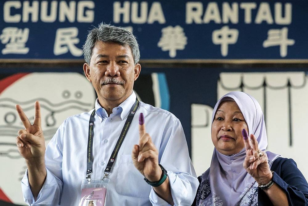 Mohamad bersama isterinya Raja Datin Seri Salbiah Tengku Nujumudin menunjukkan jari yang dicelup dakwat kekal mengundi pada Pilihan Raya Negeri di Sekolah Jenis Kebangsaan Cina (SJKC) Chung Hua, pada Sabtu. - foto Bernama