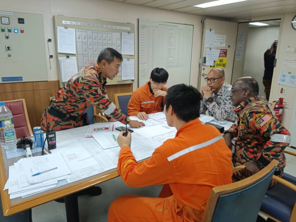 Mohd Sharenliza (tengah) berbincang bersama agensi sahabat dalam usaha memadam kebakaran kontena di kapal MV KMTC Shenzhen di Pelabuhan Klang.