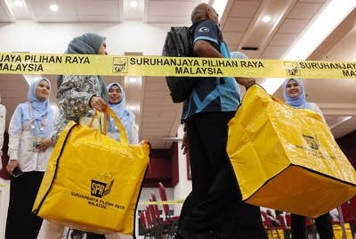 Petugas SPR membawa masuk peti undi untuk diserahkan kepada pegawai pengurus pada tinjauan di Pusat Penjumlahan Undi Rasmi, Majlis Bandaraya Kuala Terengganu. - Foto Bernama.