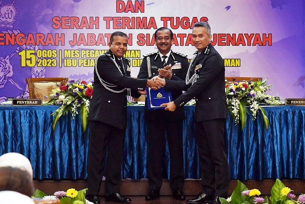 Ayob (kiri) menyampaikan plak simbolik serah terima tugas kepada Mohd Shuhaily (kanan) disaksikan Razarudin (tengah) di Mess Pegawai Ibu Pejabat Polis Bukit Aman di sini pada Selasa.
