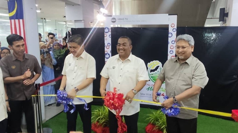 Muhammad Sanusi (dua dari kanan) menyempurnakan gimik pelancaran Program Kempen Jalur Gemilang Peringkat Negeri Kedah di sebuah pasar raya, Alor Setar pada Selasa.