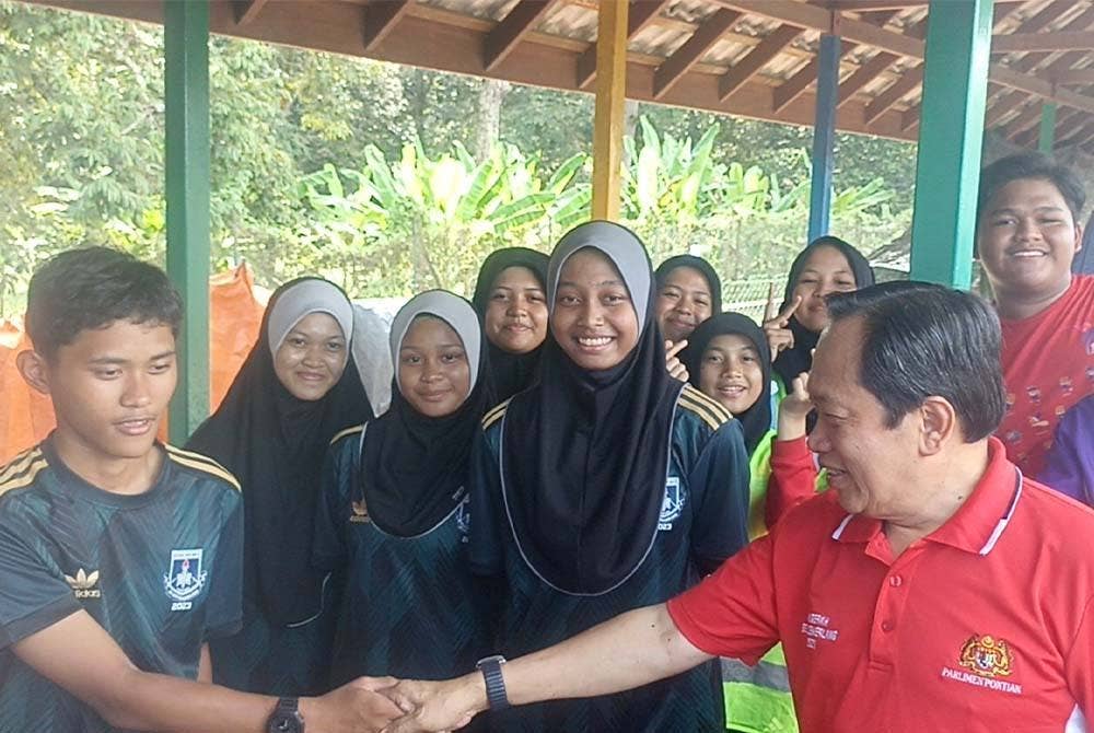 Ahmad (kanan) bersalaman dengan peserta Kejohanan Majlis Sukan Sekolah Daerah (MSSD) Pontian di SMK Tan Sri Osman Mohd Sa'at pada Selasa.