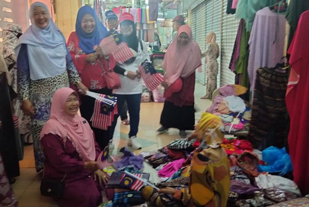 Dr Hafidzah (duduk, kiri) beramah mesra dengan peniaga Pasar Siti Khadijah ketika sesi lawatannya pada Rabu.