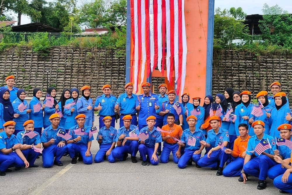 Che Adam bersama guru dan pelajar yang terlibat dalam menghasilkan gegantung Jalur Gemilang gergasi yang direntang sebagai simbolik Majlis Pelancaran Bulan Kemerdekaan Peringkat APM Pahang pada Khamis.