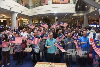 Fahmi (tengah) mengibarkan Jalur Gemilang selepas Majlis Pelancaran Mydin TikTok shop pada Khamis. - Foto: SINAR HARIAN/ MOHD RAFIQ REDZUAN HAMZAH